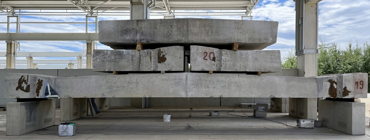 Retired concrete test girder with stacked ballast girders and temporary supports