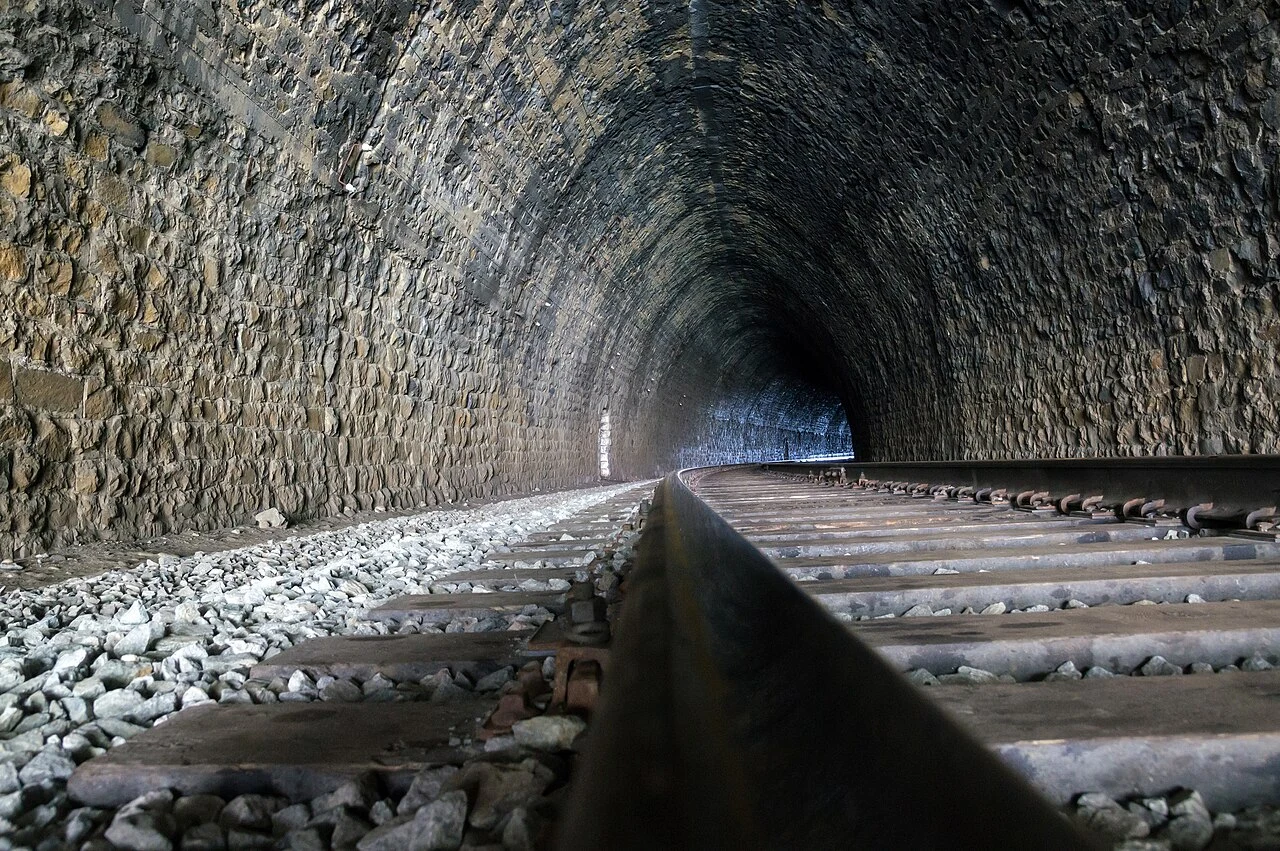 Masonry lining and tracks inside a railway tunnel