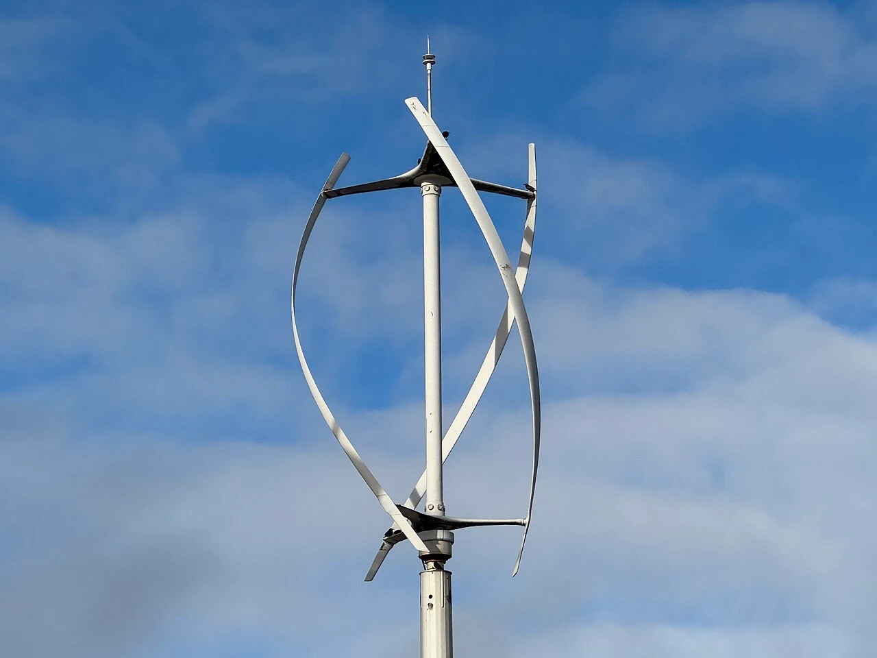 Vertical-axis wind turbine and its support against a blue sky
